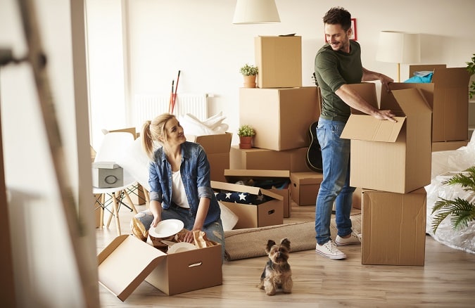 Young couple in new home with small dog